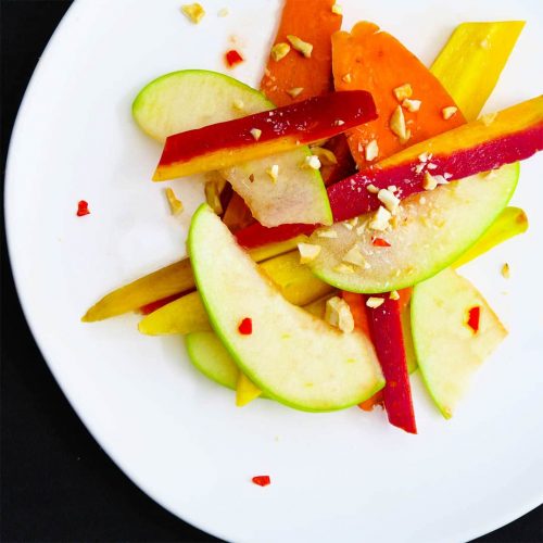 Thai Apple Salad on a white plate on a black background
