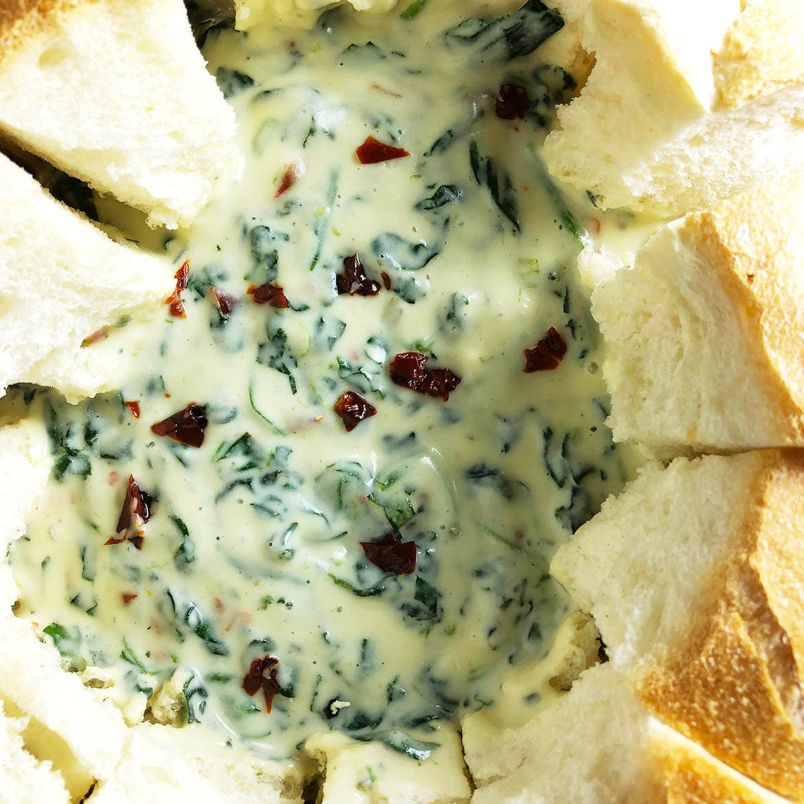 Top-down close up of Warm Spinach Dip, served in a bread bowl