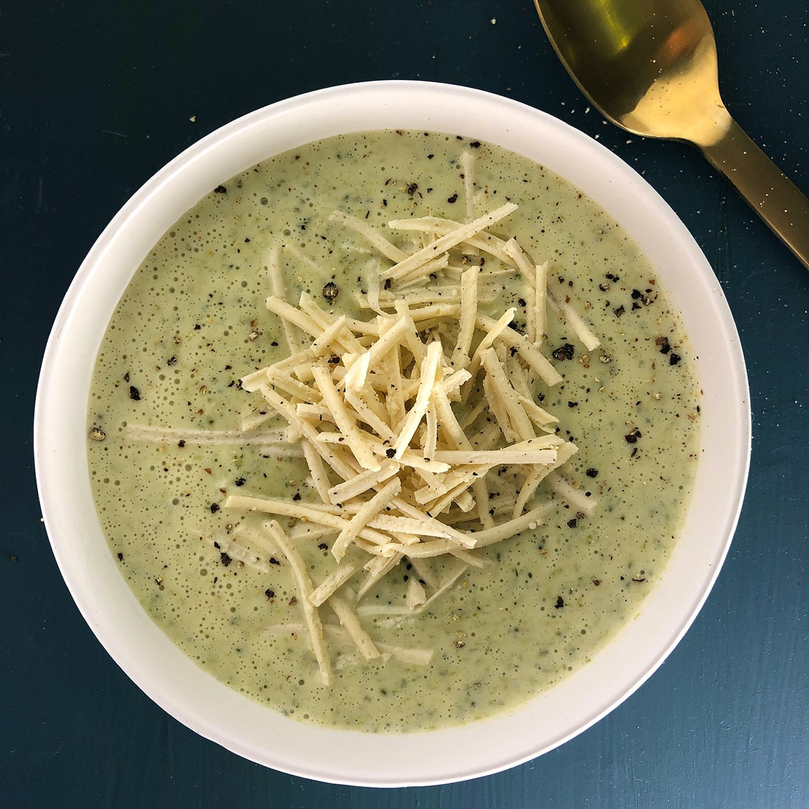 Topdown view of Vegan Broccoli Cheese Soup garnished with vegan cheese