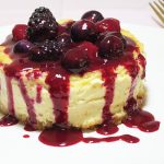 Baked lemon cheesecake, topped with triple berry fruit sauce made from raspberries, blueberries, and blackberries