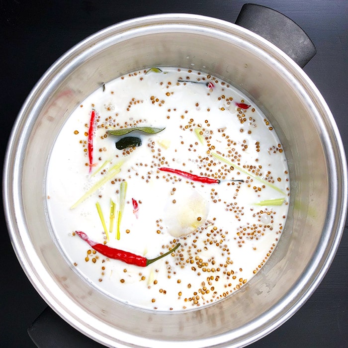 Coconut milk and emongrass, ginger, coriander, lime, and Thai chilis in a large saucepan