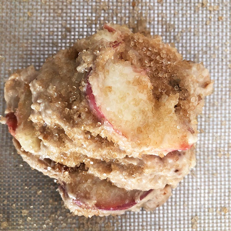 Top-down view of uncooked donut peach scones, sprinkled with turbinado sugar.