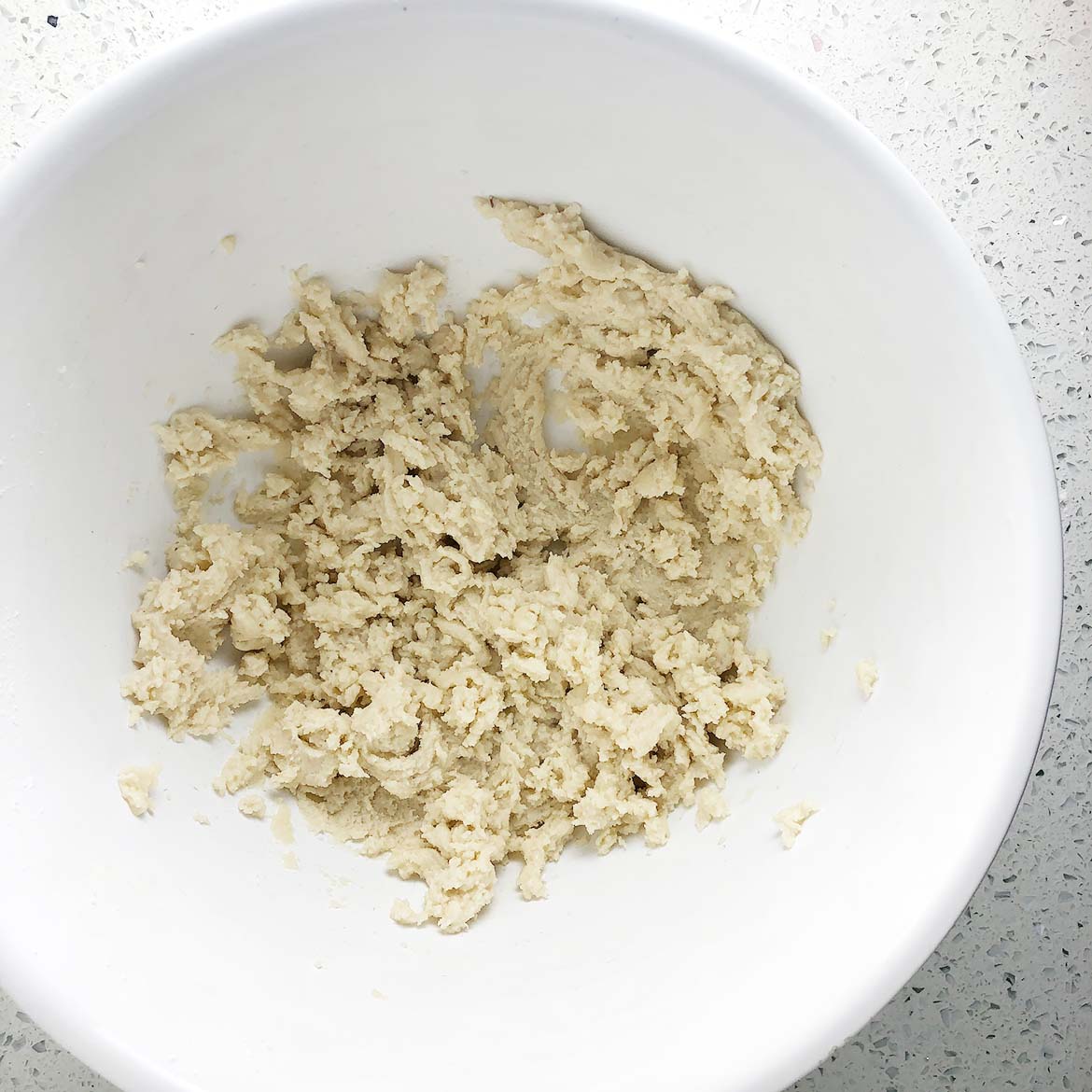 Top-down view of mixing bowl containing dough for Vegan Brown Butter Shortbread Cookies