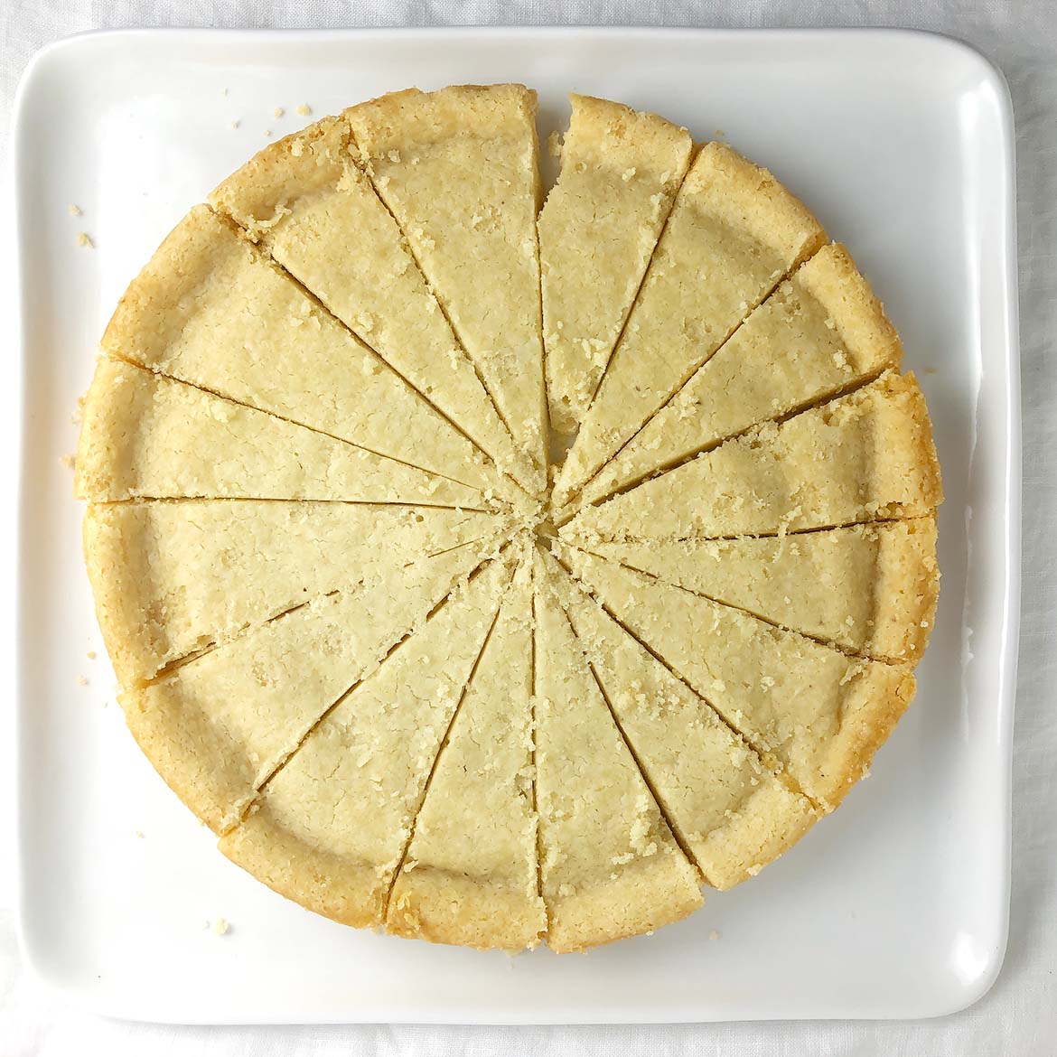 Top-down shot of Vegan Brown Butter Shortbread, cut into triangles on a white plate