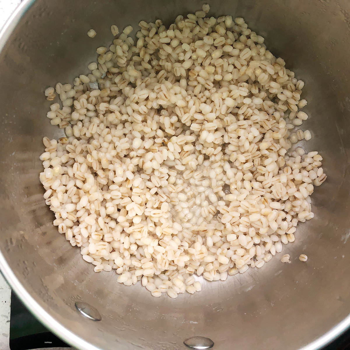 Top down view of a saucepan with cooked barley. This is the first step i making 1-Pot Barley Porridge.