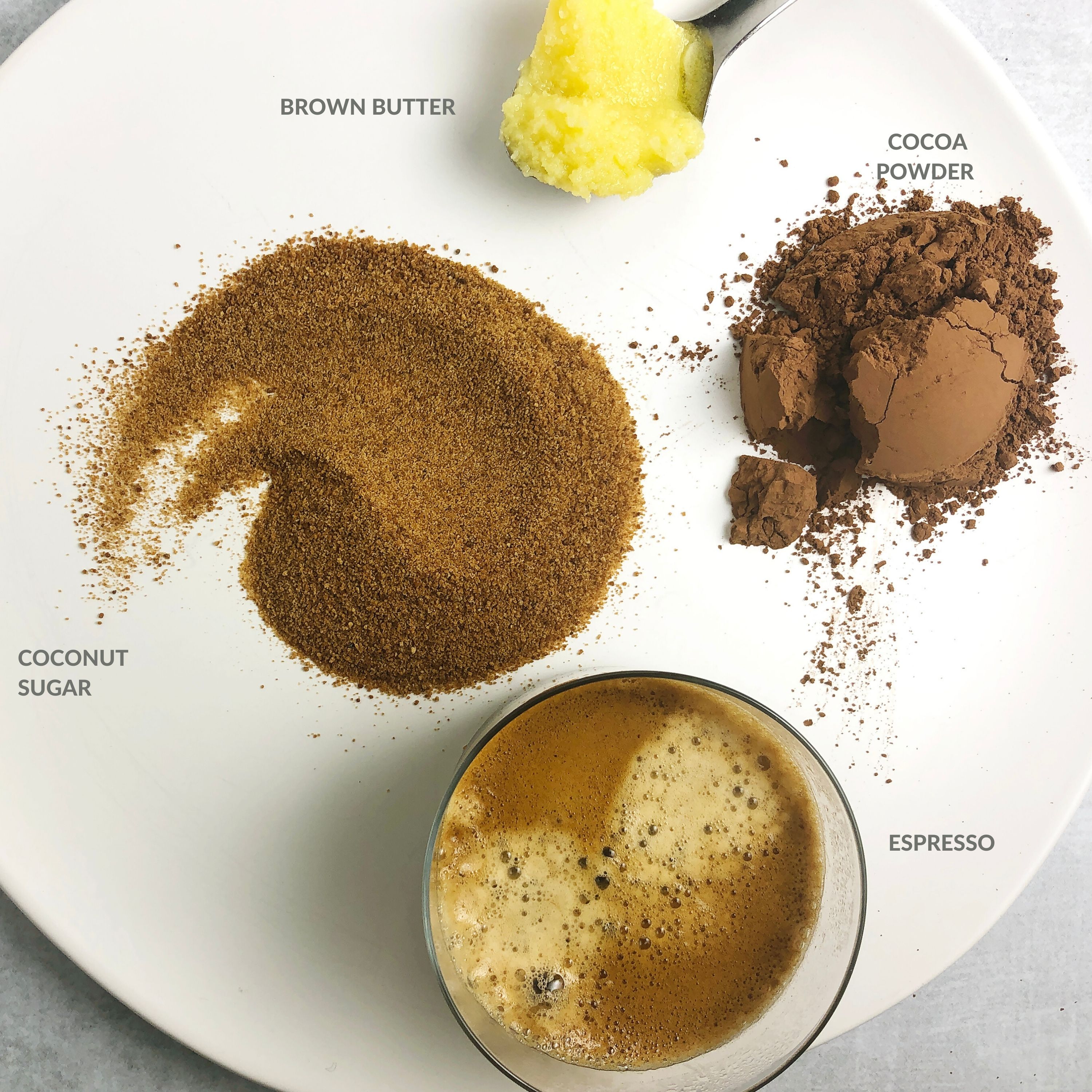 Top-down view of ingredients for Brown Butter Chocolate Syrup, including brown butter, cocoa powder, espresso, coconut sugar