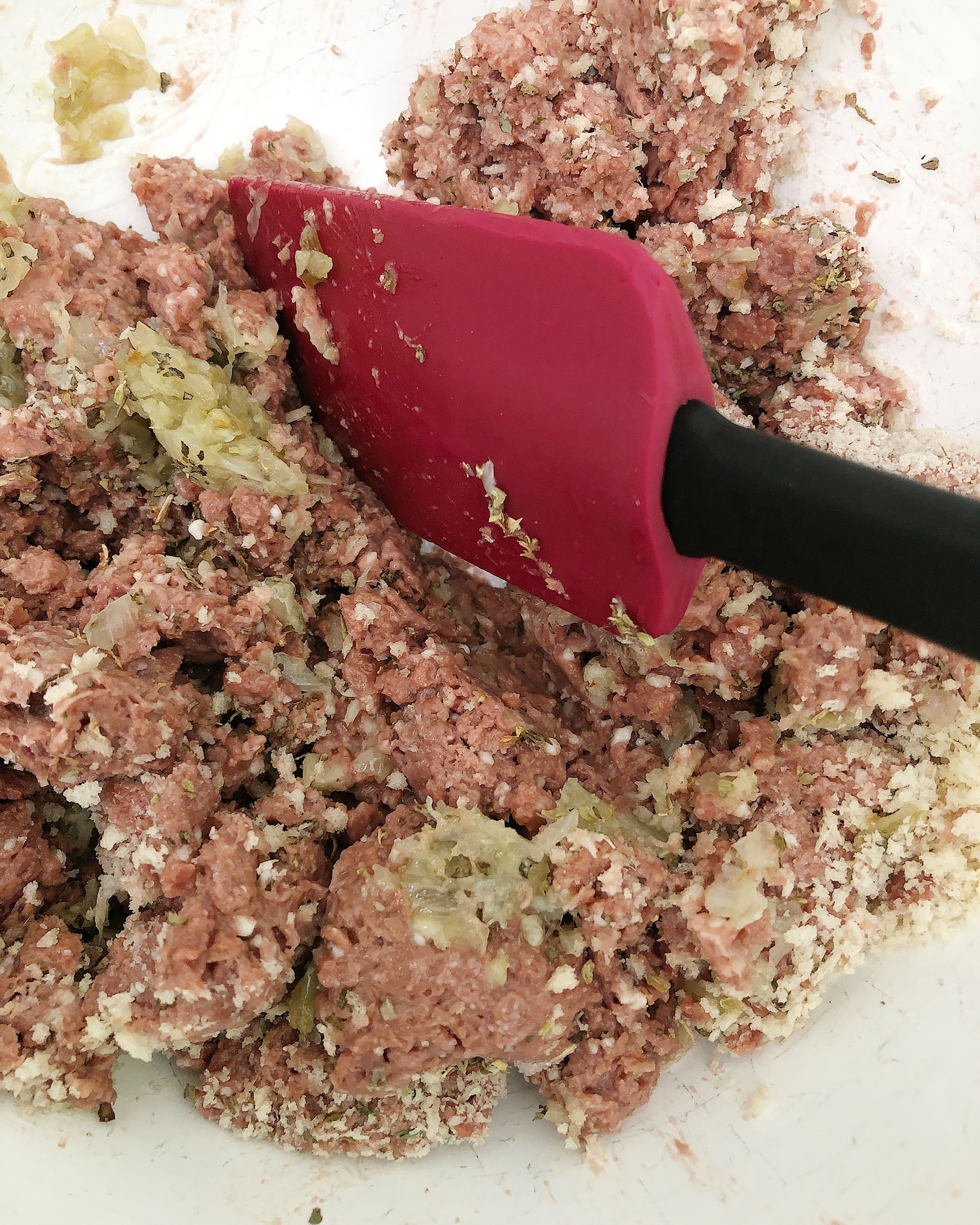 Top-down shot of Beyond Meat and spices - breaking up the meat with a spatula