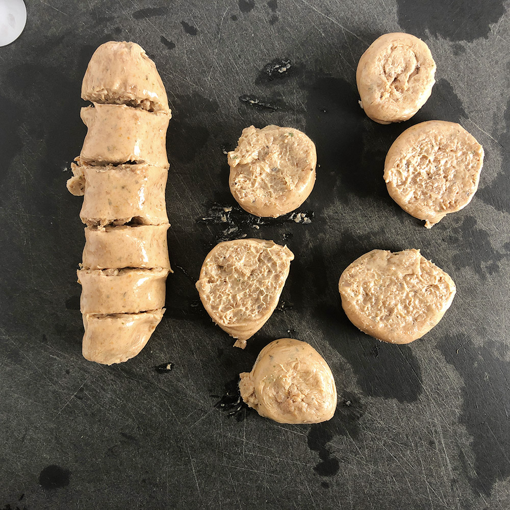 Top down view of uncooked Beyond Meat Mild Italian Sausage. Cut each link into 6 coin-shaped pieces. 