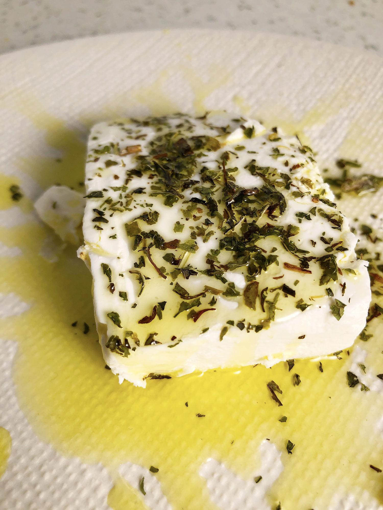Close up of Macedonian Feta cheese drizzled with olive oil and dried mint