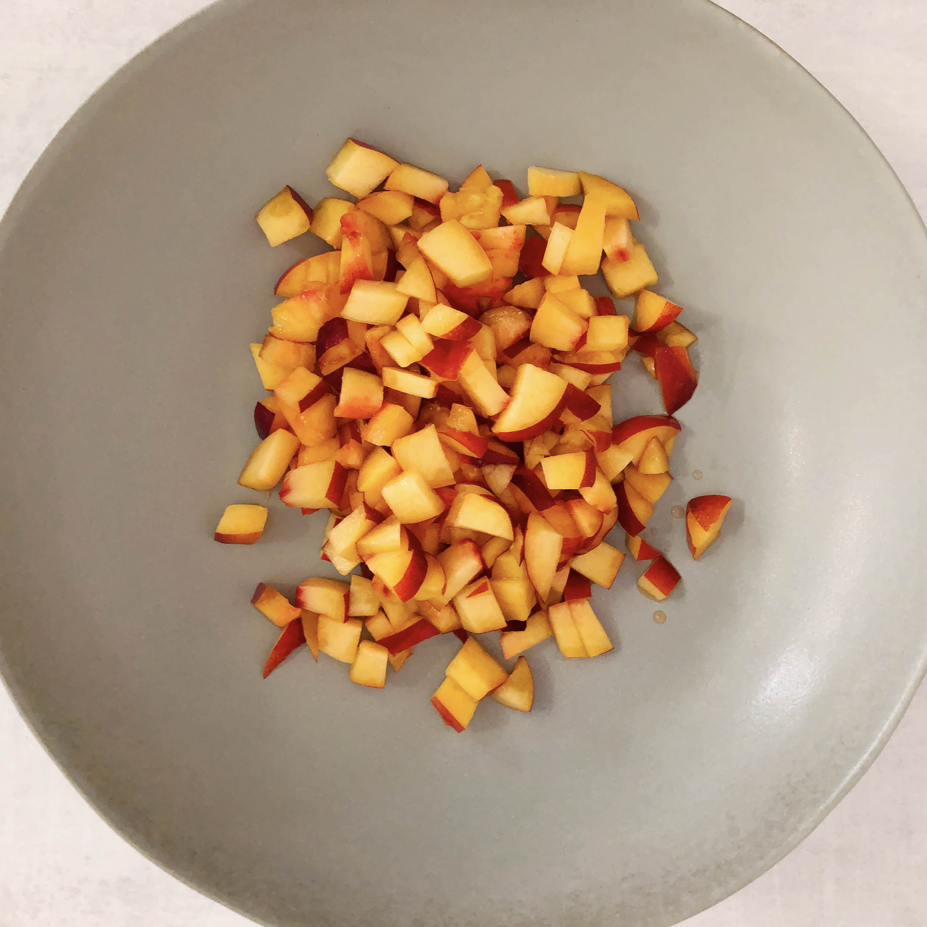 Top-down view of diced nectarines in a serving bowl