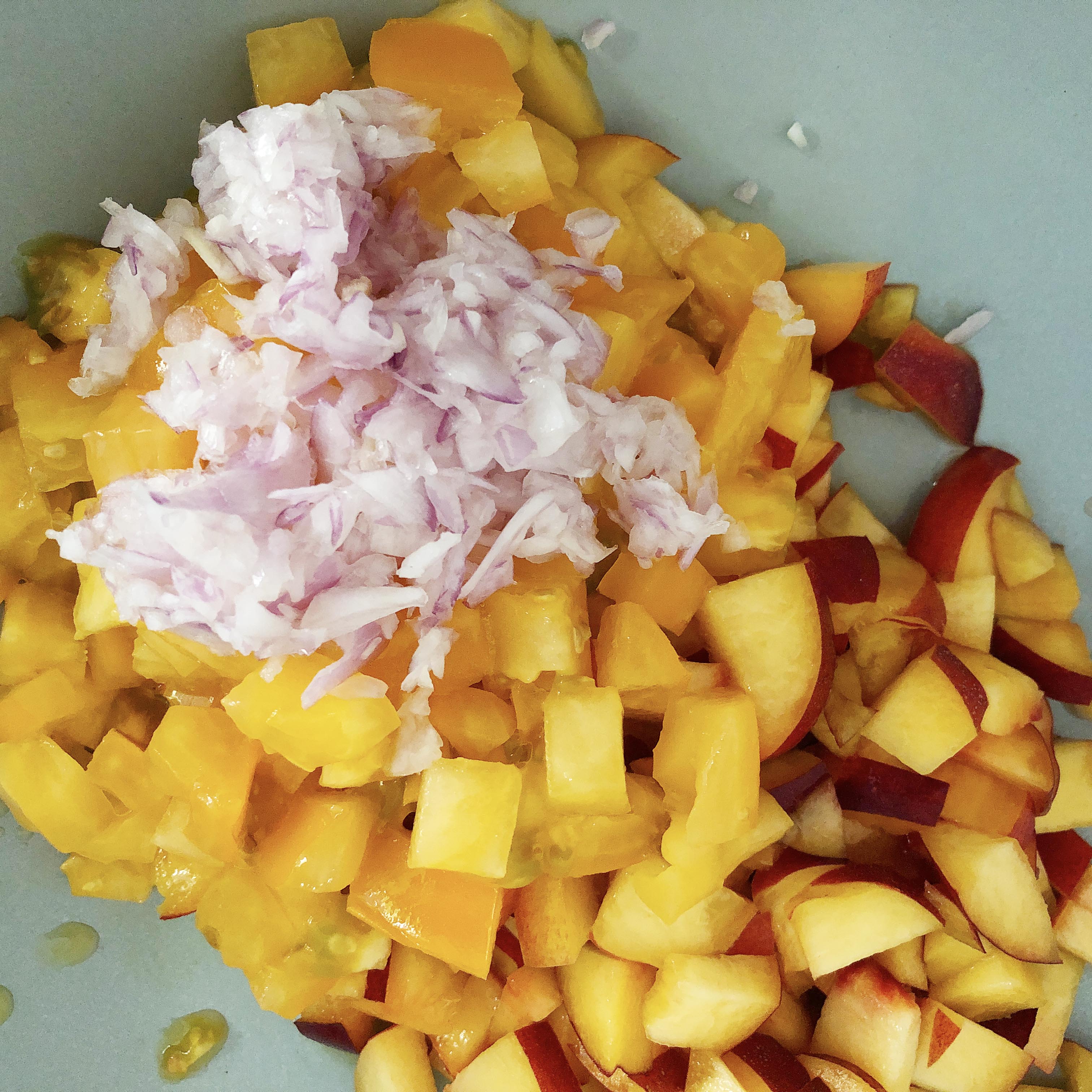 Diced shallots added to nectarines and tomatoes. Making nectarine salsa.