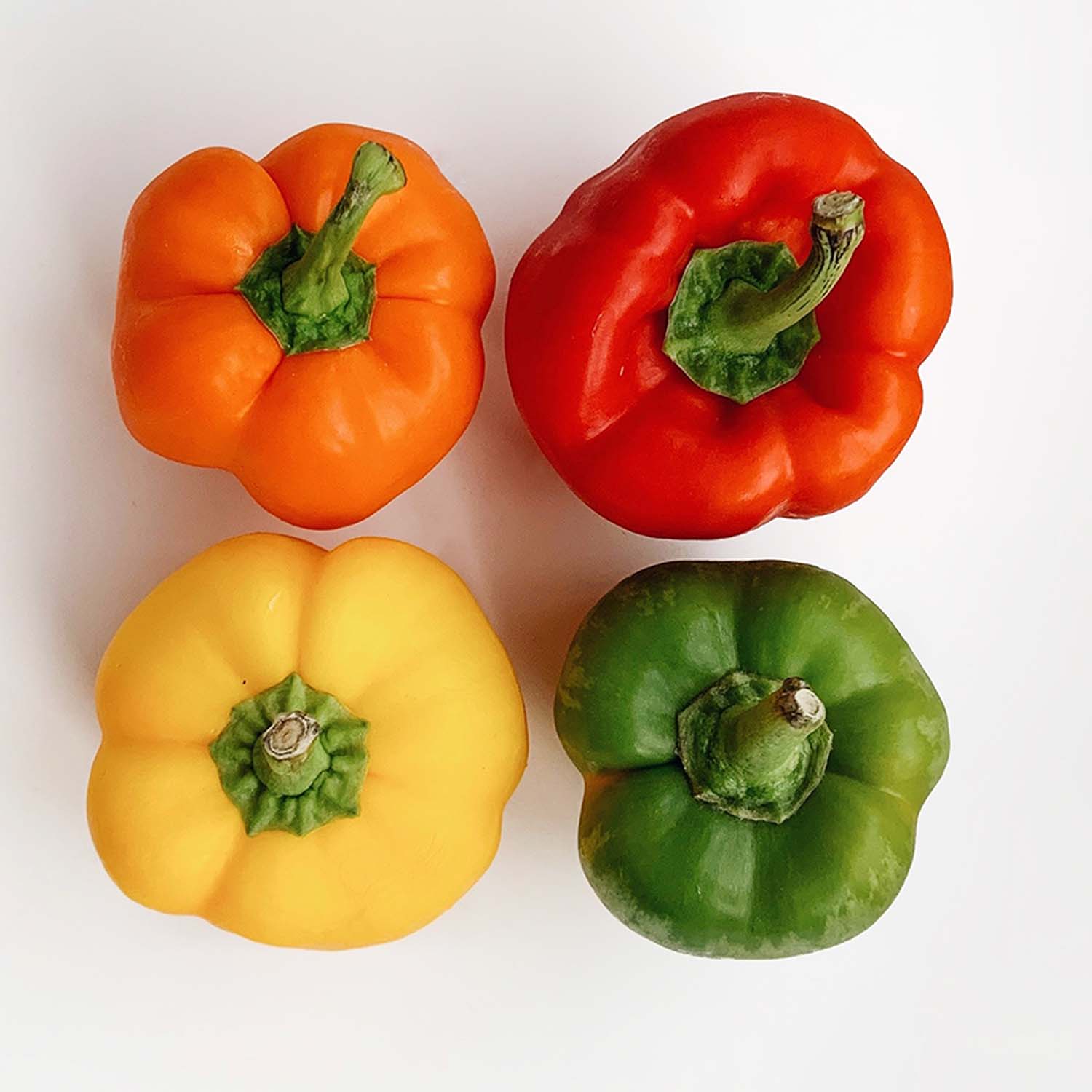 A top-down view of orange, red, yellow, and green pepper