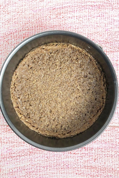 Top-down view of unbaked crust in springform pan