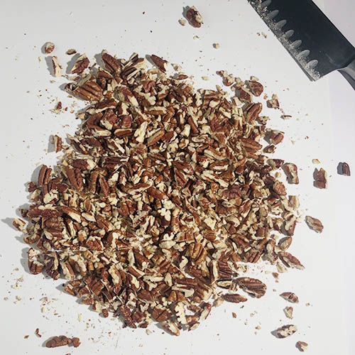 Top-down view of toasted, chopped pecans