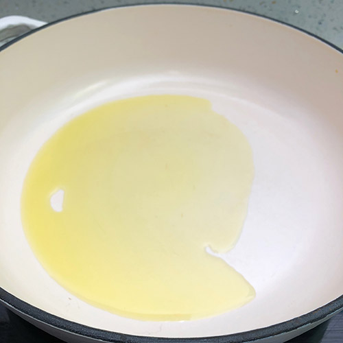 Olive oil in a white cast iron pan