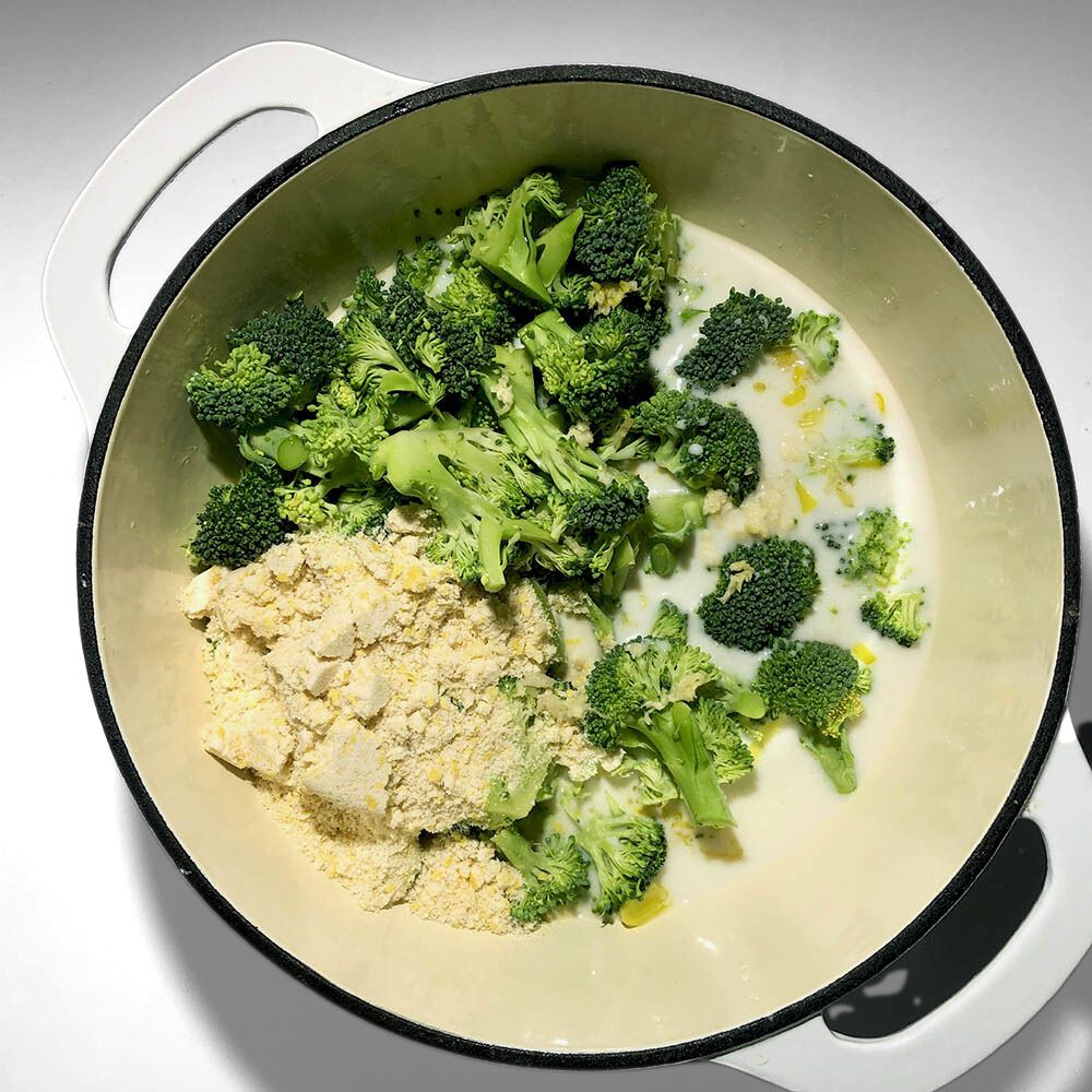 Top-down view of broccoli, Mother Mix, garlic added to the soup pot.