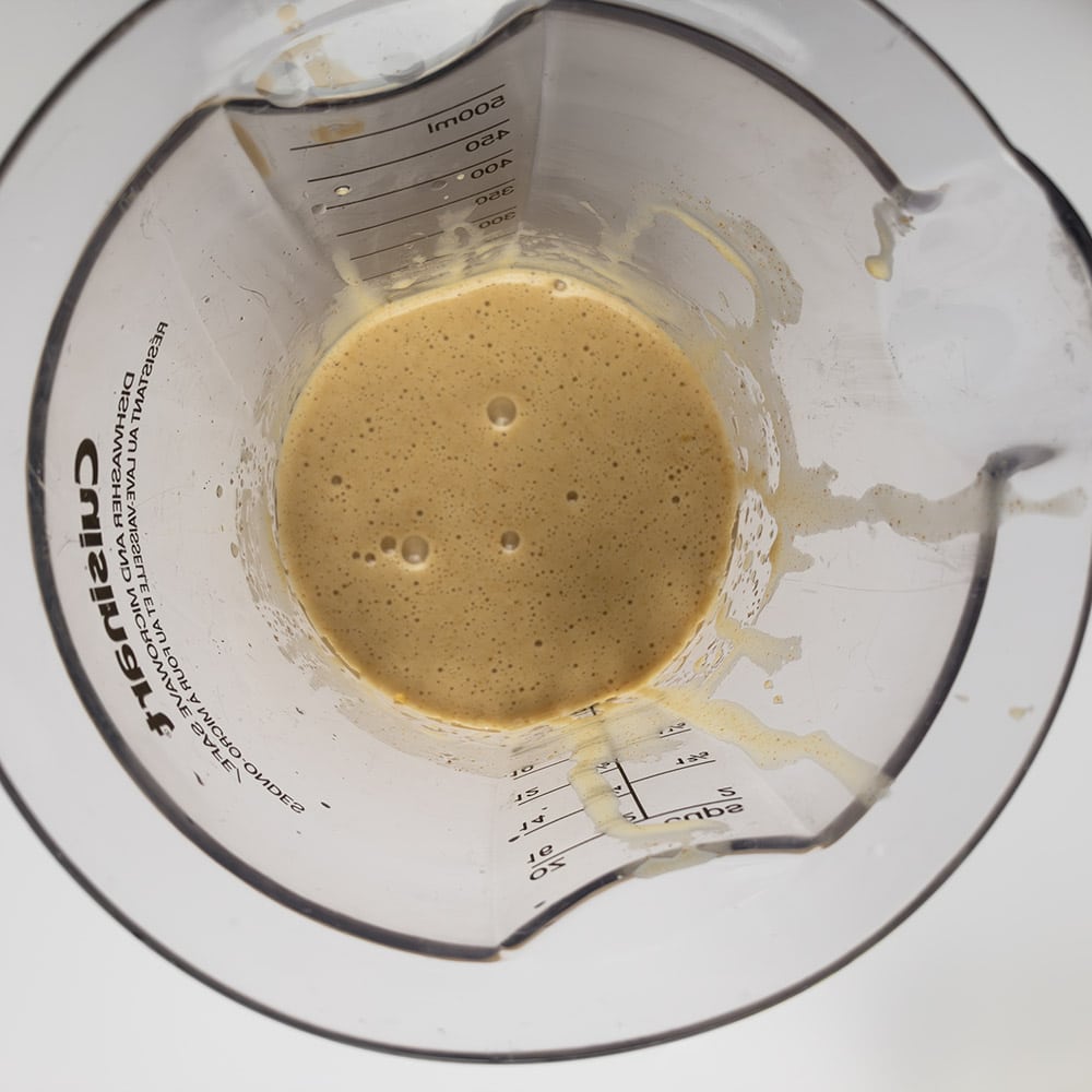Top-down view of Smoky Maple Bacon Mayonnaise in a tall measuring cup, after the initial blending