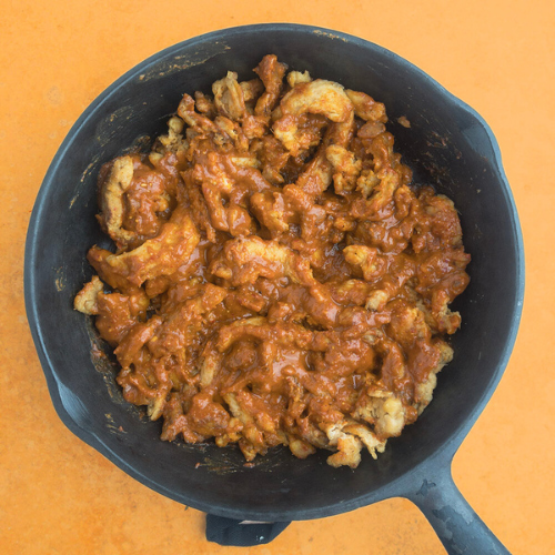 Top-down view of soy curls and peanut sauce in a frying pan